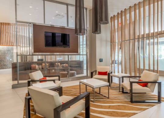 a lobby with chairs and tables and a television at The Acadia at Metropolitan Park, Arlington, Virginia